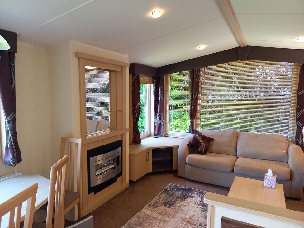 A living room with a sofa and a dining table at Emma No.6 in Llandegfan