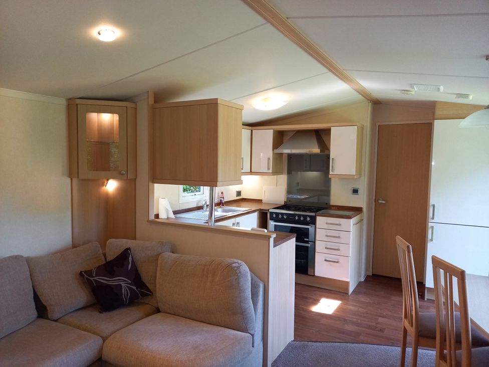 A living room with a kitchen and dining area at Emma No.6 Llandegfan