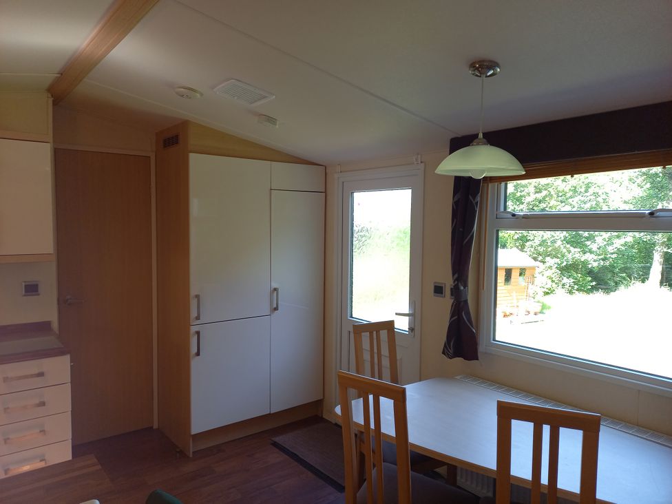 A kitchen with a dining table and chairs at Emma No.6 in Llandegfan