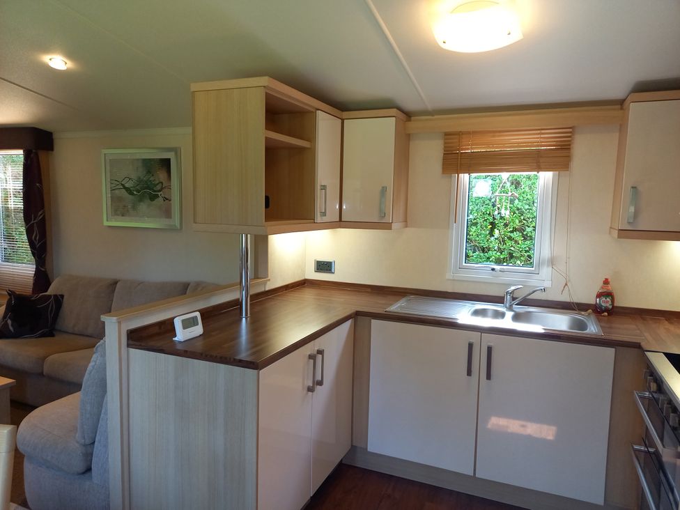 A kitchen with cabinets and a sink at Emma No.6 in Llandegfan