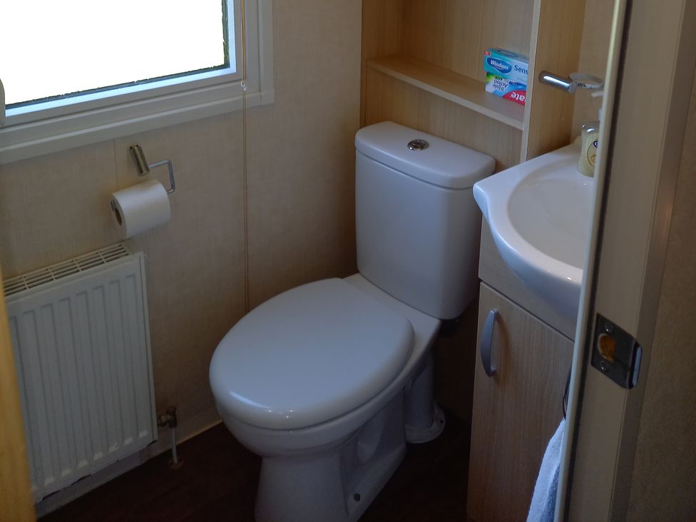 A bathroom with a toilet and sink at Emma No.6 Llandegfan