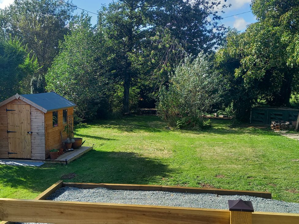 An outdoor space with a shed and grass area at Emma 6 in Llandegfan