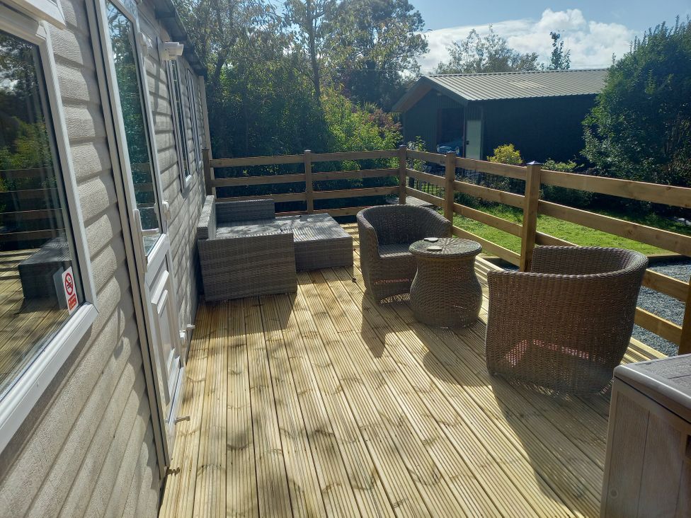 An outdoor seating area with wicker furniture at Emma 6 Llandegfan