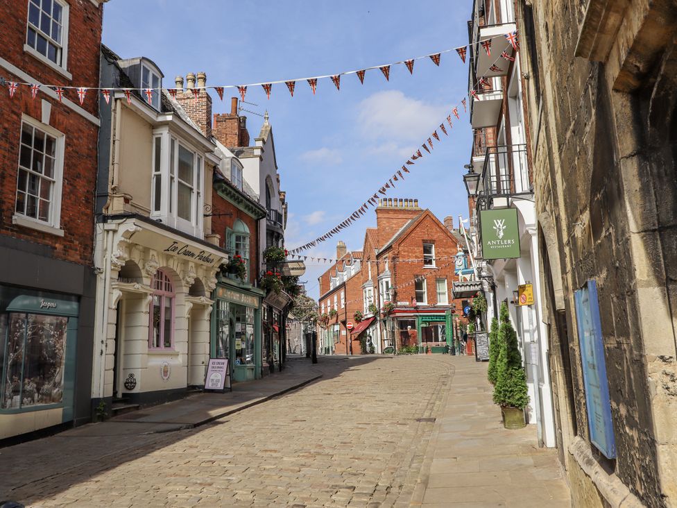 An outdoor street view with shops and banners at Madje Apartment in Lincoln