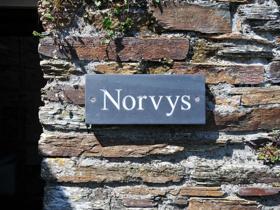 A sign reading Norvys on a stone wall at Norvys in Bossiney
