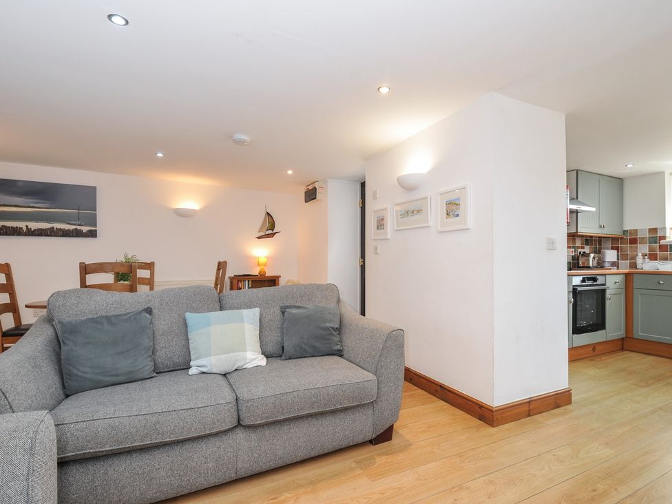 A living room with a sofa and dining area at Norvys in Bossiney