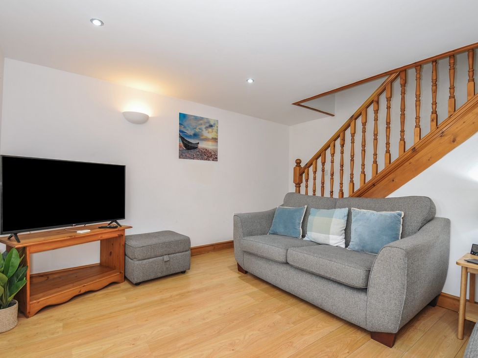 A living room with a sofa and television at Norvys in Bossiney