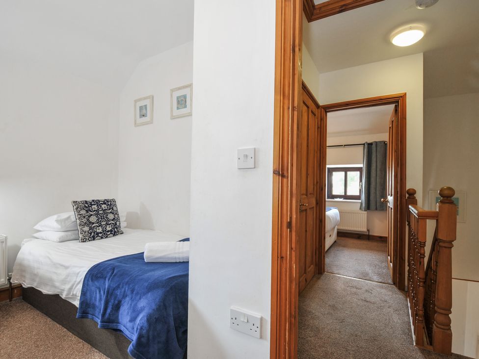 A bedroom with a bed and doorways at Norvys in Bossiney