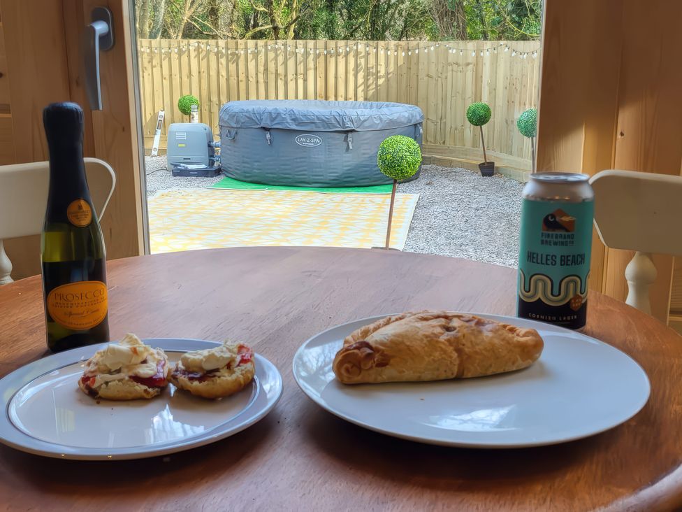 A dining area with food and drinks overlooking the garden at Sea La Vie Perranporth
