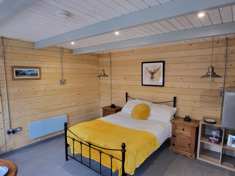 A bedroom with a bed and nightstands at Sea La Vie in Perranporth