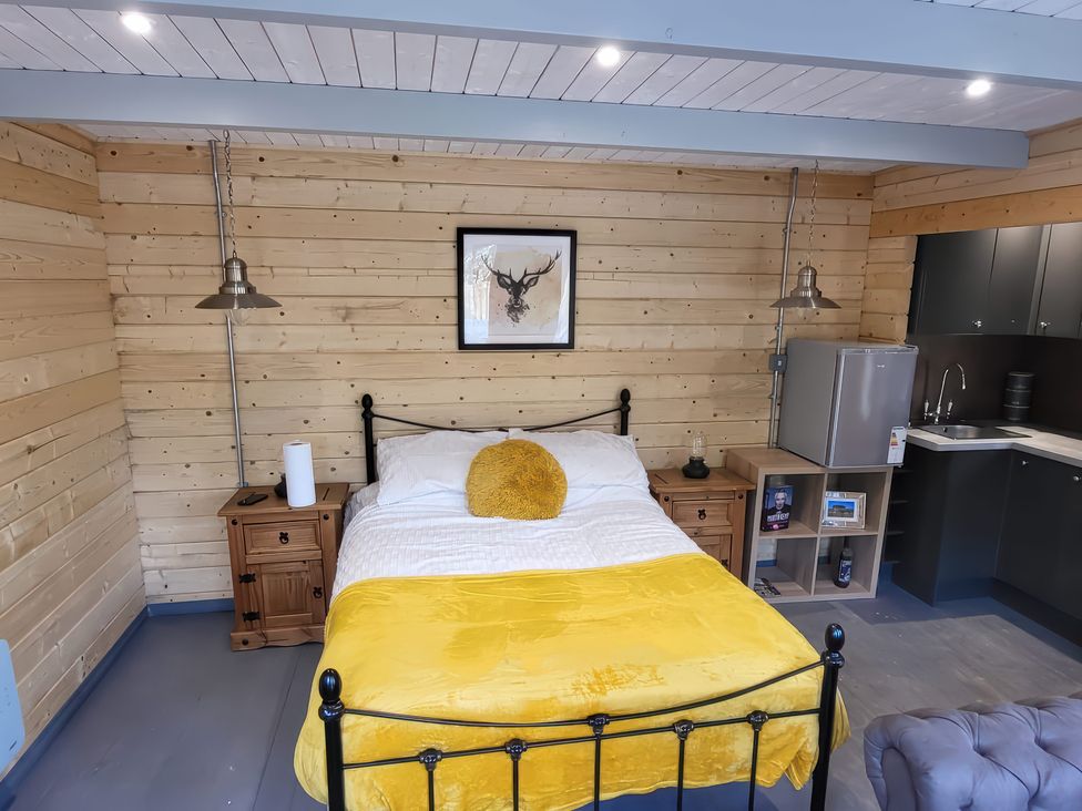 A bedroom with a bed and kitchenette at Sea La Vie in Perranporth