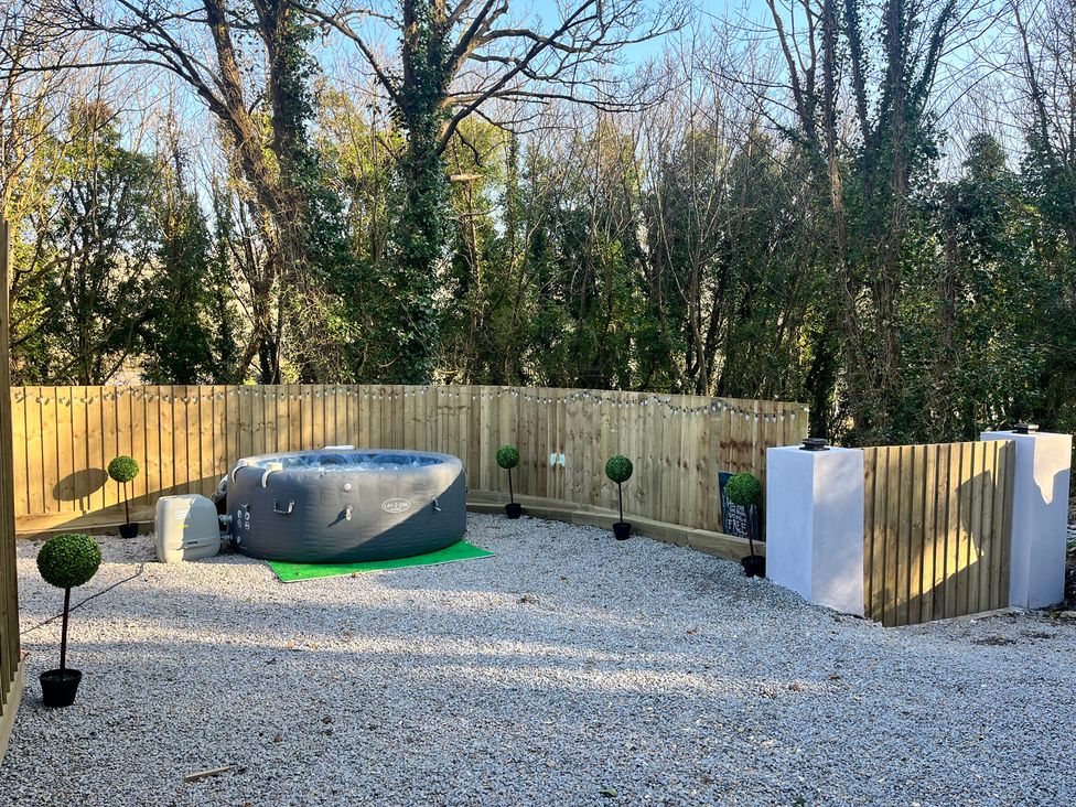 An outdoor space with a hot tub and plants at Sea La Vie in Perranporth