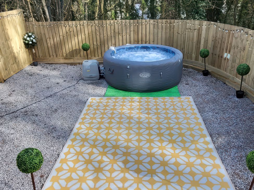 An outdoor area with a hot tub and a patterned mat at Sea La Vie in Perranporth