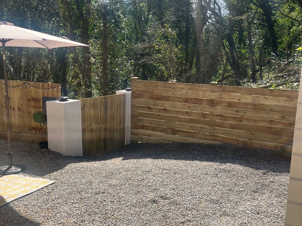 A garden area with a wooden fence and gravel ground at Sea La Vie in Perranporth
