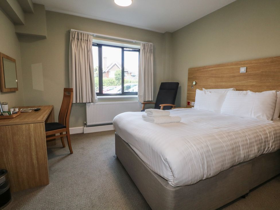 A bedroom with a bed and a desk at Bedroom 4 in Littlehampton