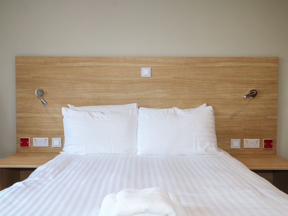 A bedroom with a bed and light fixtures at Bedroom 4 in Littlehampton