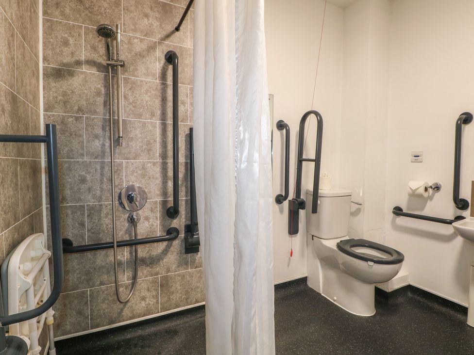 A bathroom with shower, toilet, and grab bars at Bedroom 4 in Littlehampton