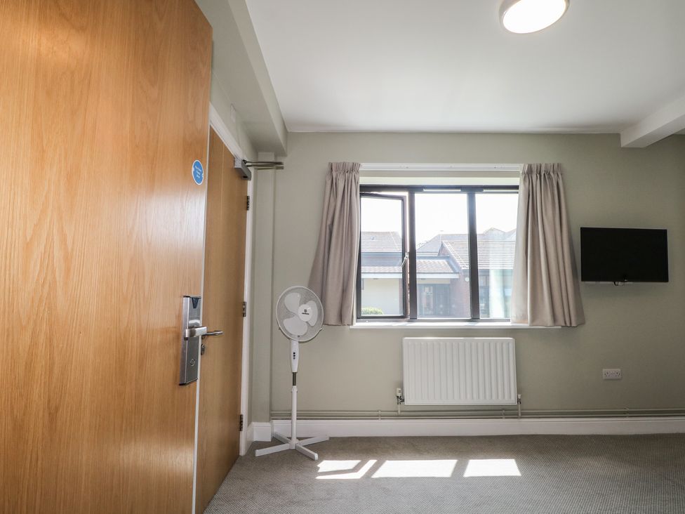 A bedroom with a window and fan at Bedroom 6 in Littlehampton