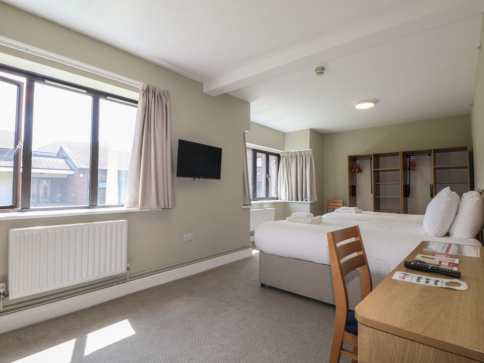 A bedroom with a bed, desk, chair, and television at Bedroom 6 in Littlehampton