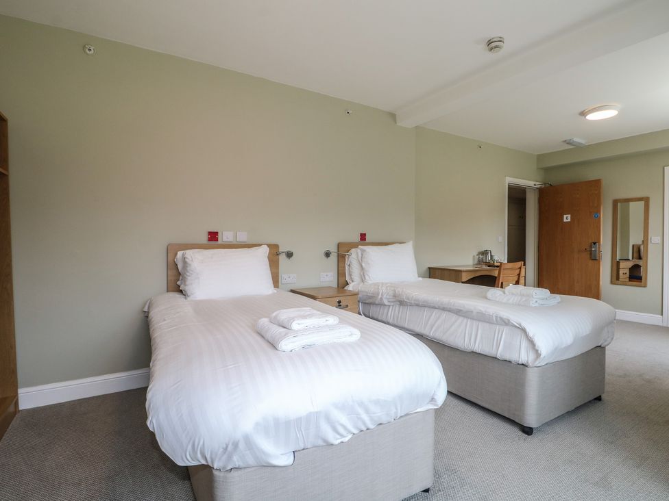 A bedroom with two beds and a table at Bedroom 6 Littlehampton