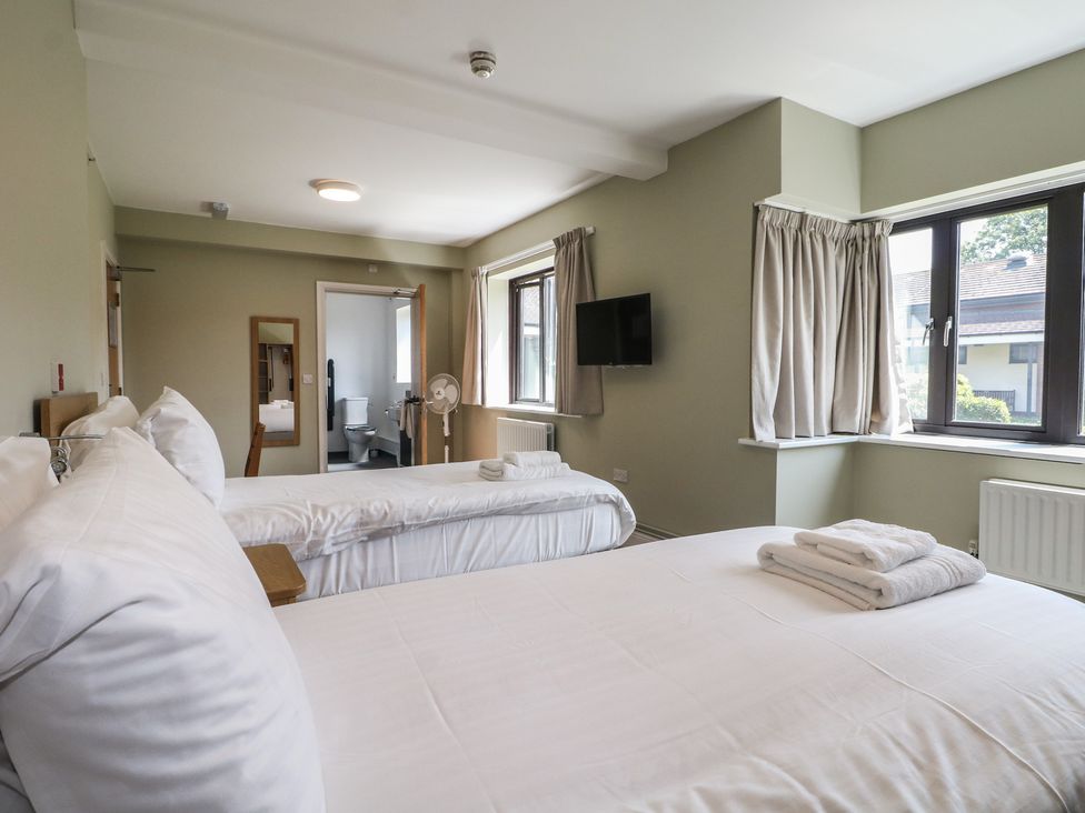 A bedroom with two beds and a television at Bedroom 6 in Littlehampton