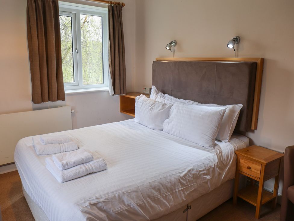 A bedroom with a bed and bedside table at Bedroom 33 