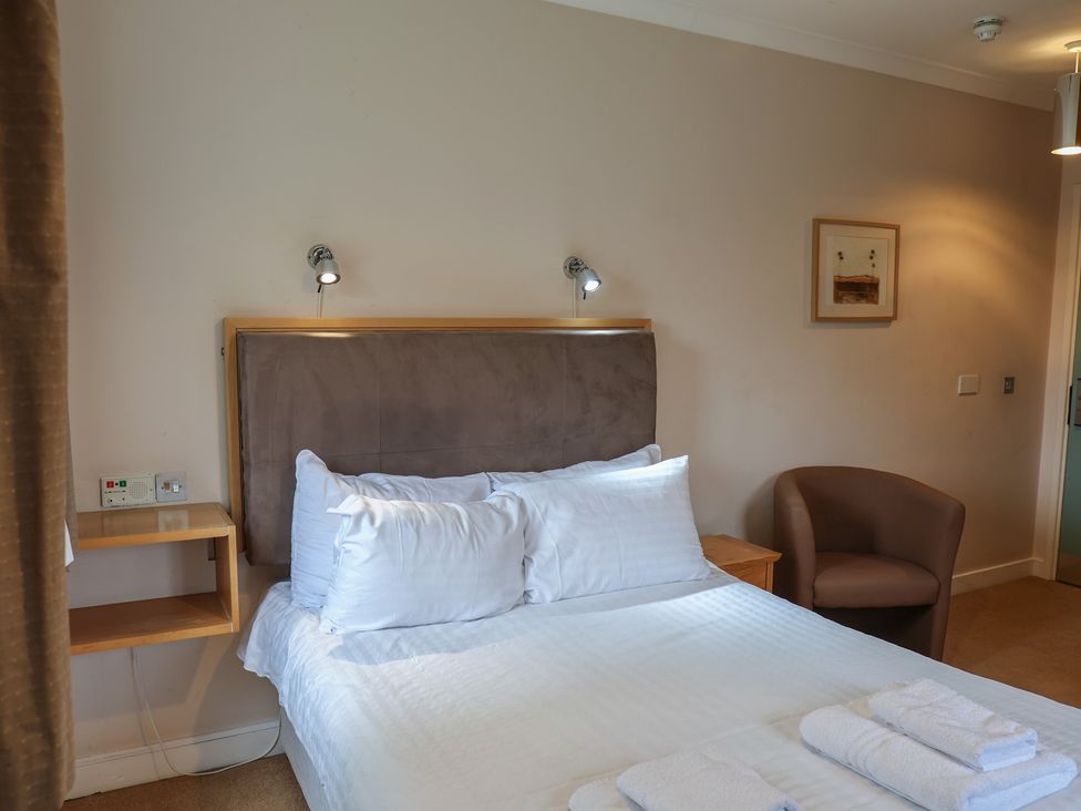 A bedroom with a bed and chair at Bedroom 33