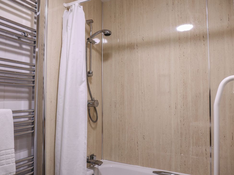 A bathroom with a shower and towel rack at Bedroom 33