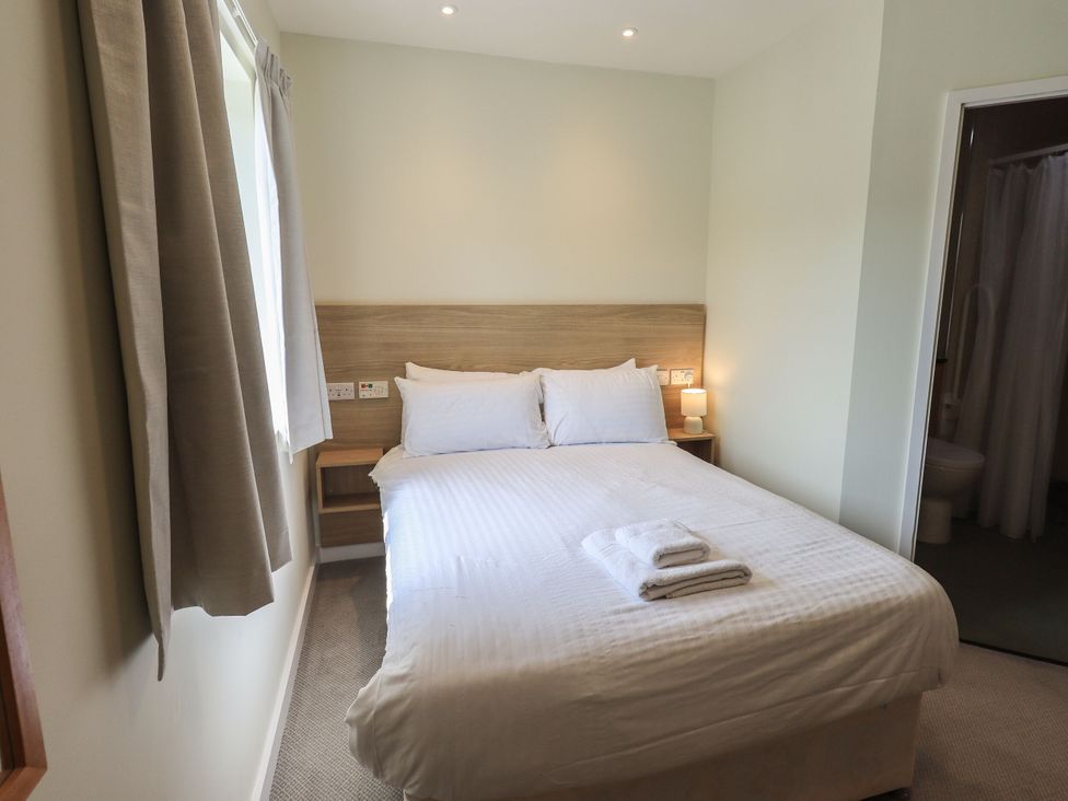 A bedroom with a double bed and en-suite bathroom at Eamont Park First-floor Double Bedroom in Penrith