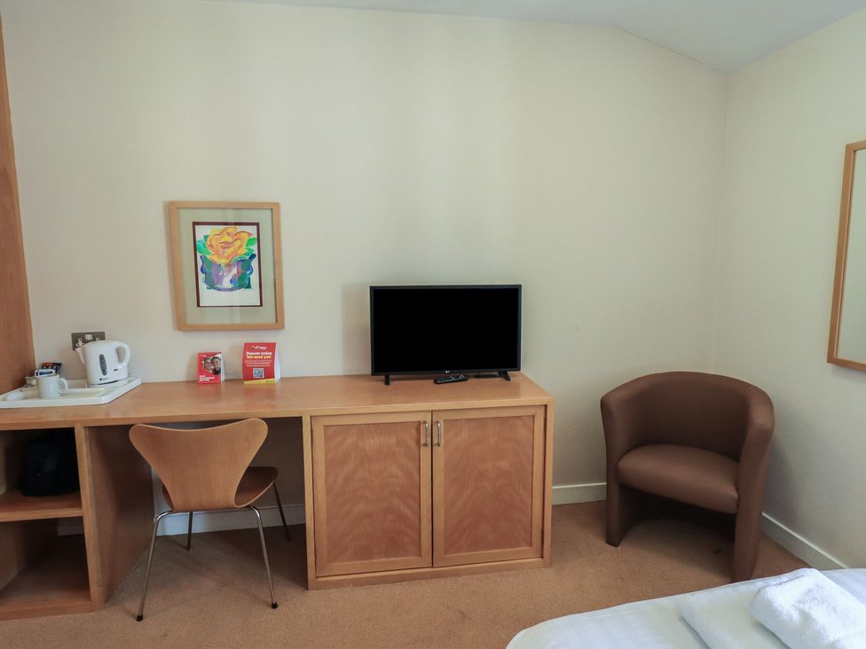 A bedroom with a desk and television at Bedroom 41 in Penrith