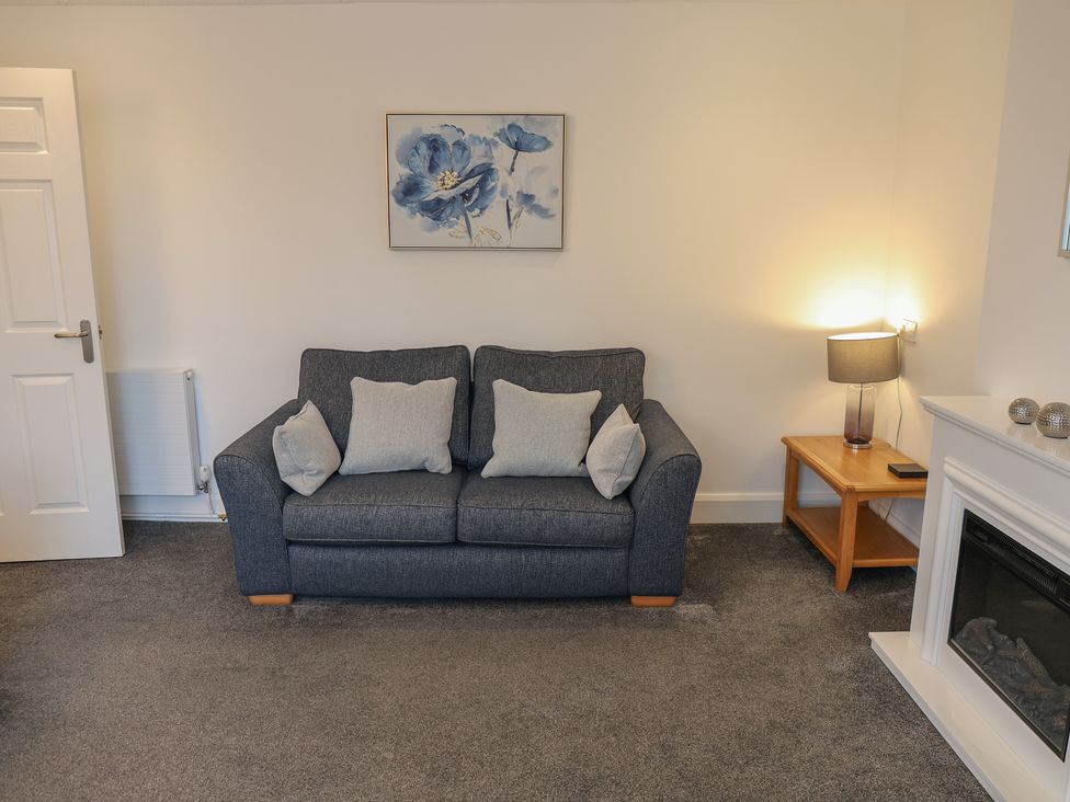 A living room with a sofa and a side table at Bungalow 19 Eamont Park Penrith