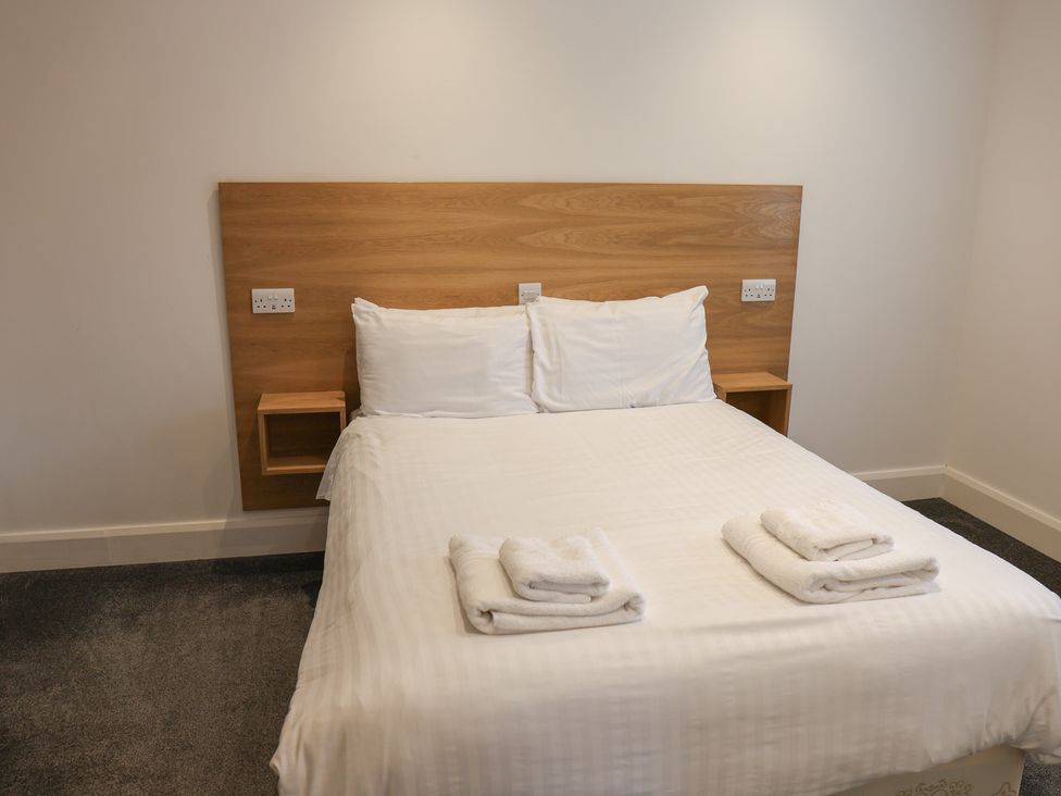 A bedroom with a bed and nightstand at Bungalow 19 Eamont Park Penrith