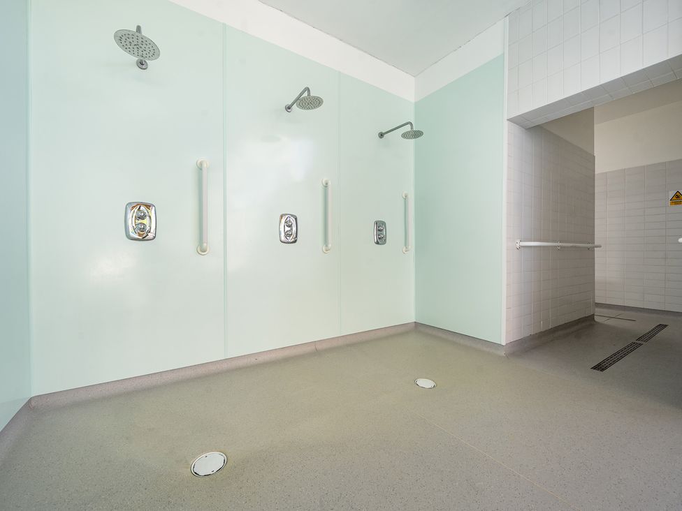 A shower area with multiple showerheads and grab bars at Jubilee Two Bedroom Bungalow Pet Free in Penrith