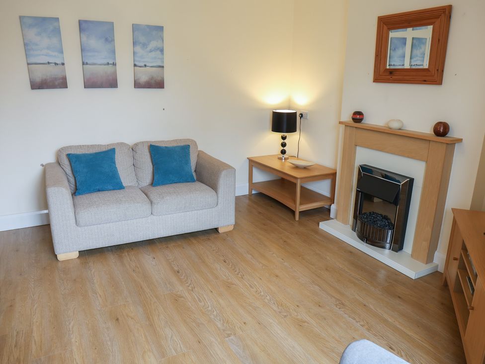A living room with a sofa and fireplace at Bungalow 15 Eamont Park Penrith