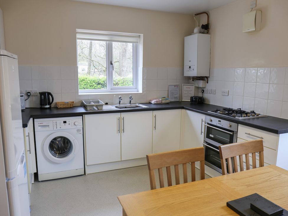 A kitchen with a washing machine and stove at Bungalow 15 Eamont Park Penrith