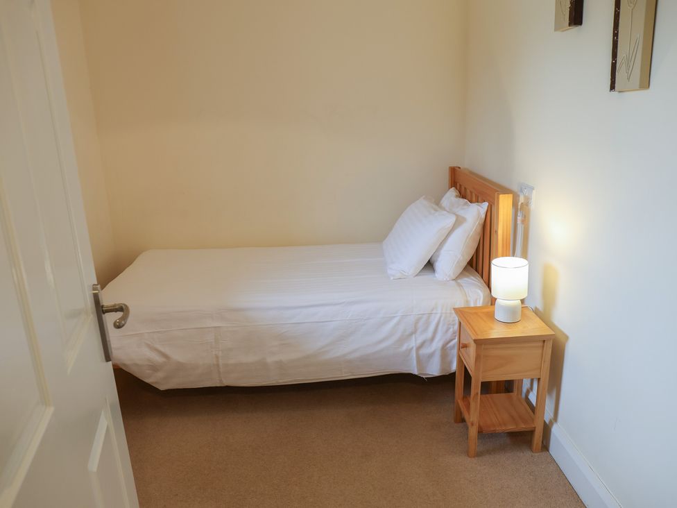 A bedroom with a bed and lamp at Bungalow 15 Eamont Park in Penrith