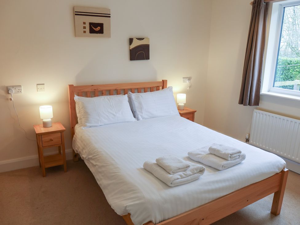 A bedroom with a double bed and bedside tables at Bungalow 15 Eamont Park Penrith