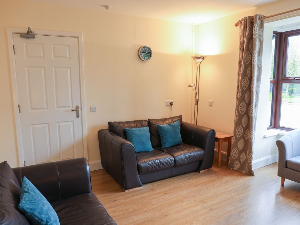 A living room with sofas and a lamp at Bungalow 14 Eamont Park in Penrith