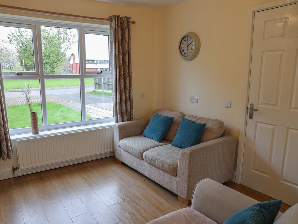 A living room with a sofa and window at House 8 Eamont Park in Penrith