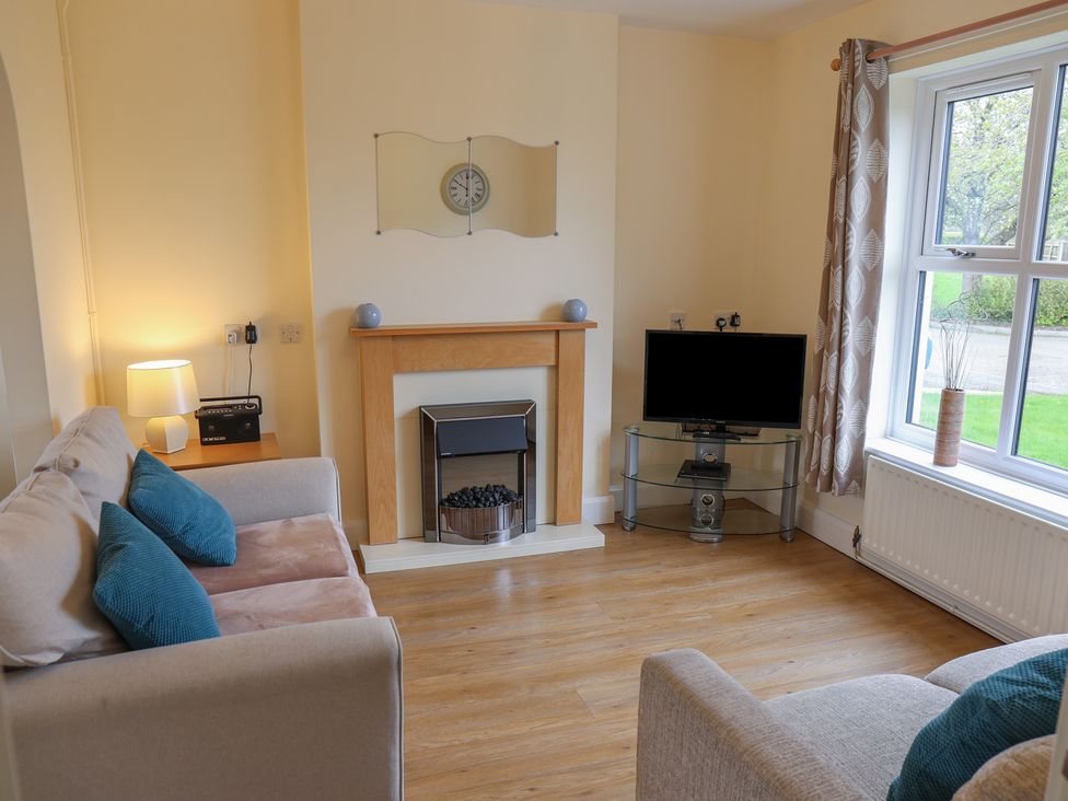 A living room with a sofa and television at House 8 Eamont Park in Penrith