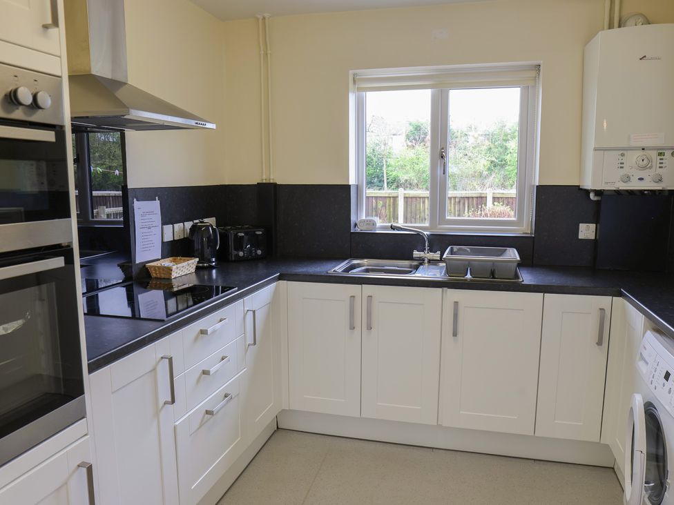 A kitchen with sink and appliances at House 8 Eamont Park Penrith