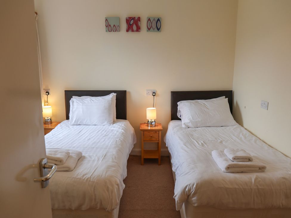 A bedroom with two single beds and nightstands at House 8 Eamont Park in Penrith