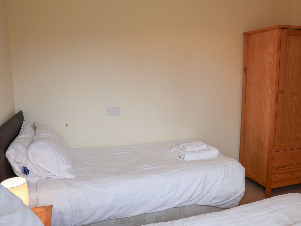 A bedroom with a bed and wardrobe at House 8 Eamont Park in Penrith