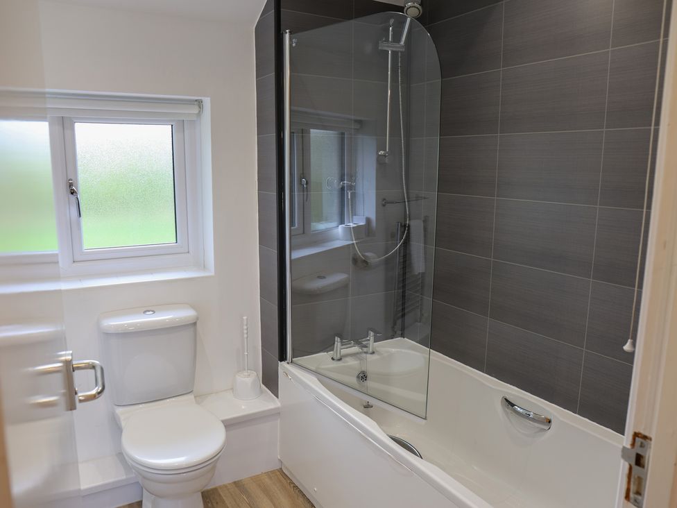 A bathroom with a bathtub and toilet at House 8 Eamont Park in Penrith