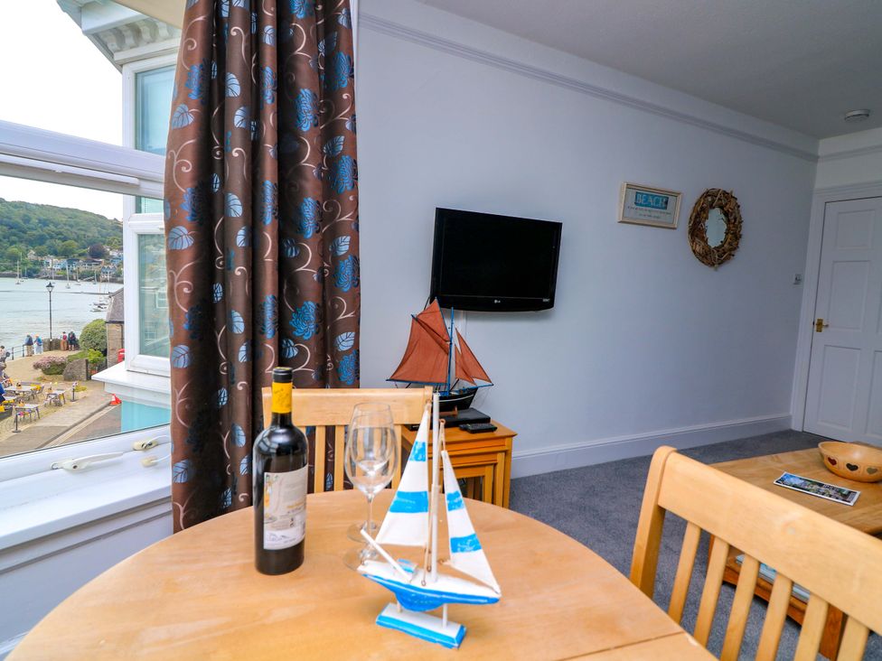 A living room with a table, wine bottle, and model sailboat at Castleview Apartment, 21 South Embankment Dartmouth