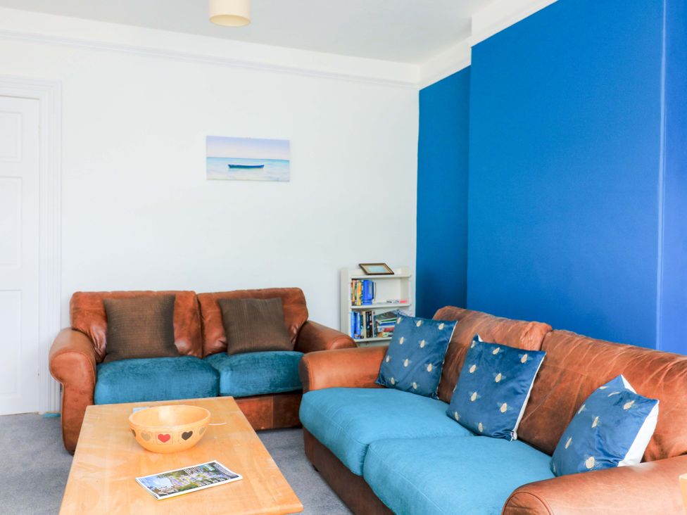 A living room with sofas, a coffee table, and a bookshelf at Castleview Apartment, 21 South Embankment, Dartmouth