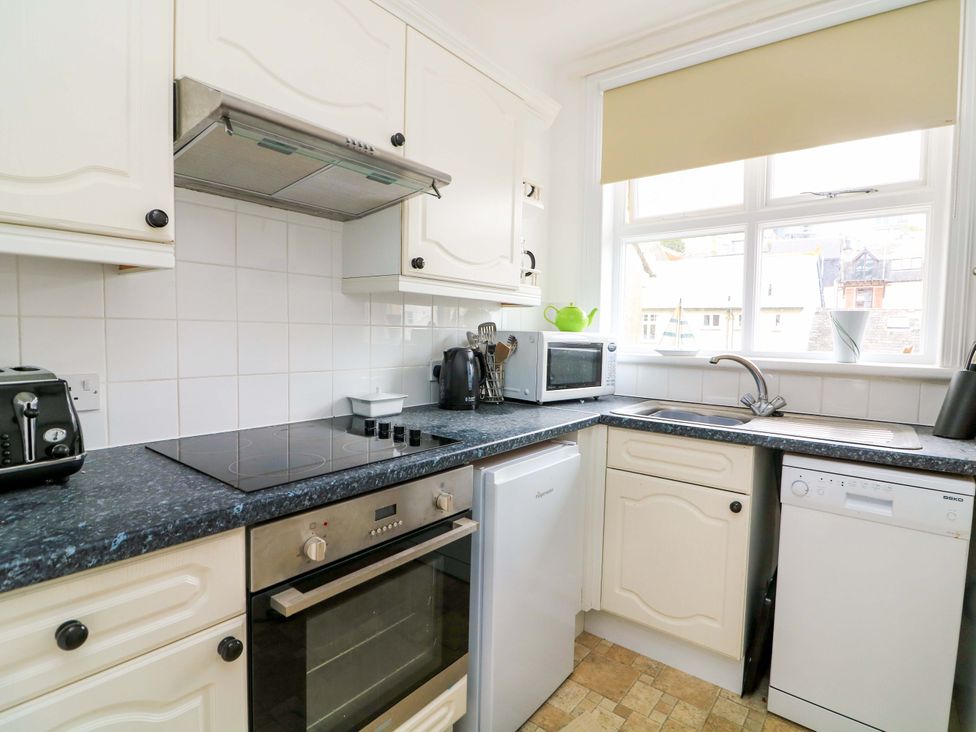 A kitchen with appliances and cabinets at Castleview Apartment, 21 South Embankment in Dartmouth