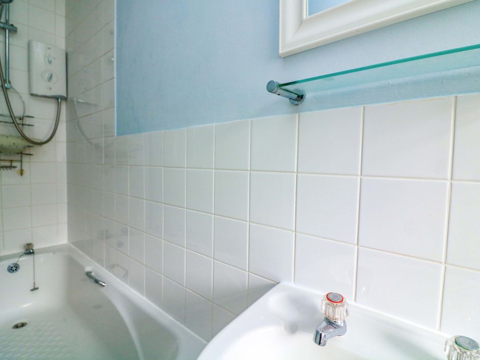 A bathroom with a bathtub and showerhead at Castleview Apartment, 21 South Embankment in Dartmouth