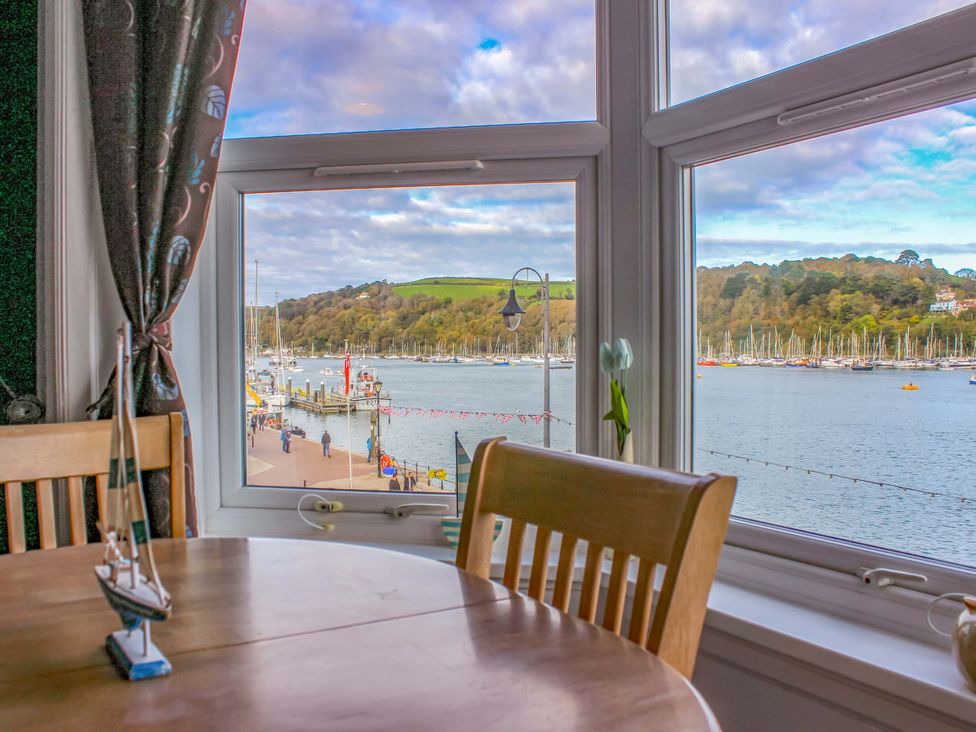 A dining room with a view of boats in the marina at Castleview Apartment, 21 South Embankment Dartmouth