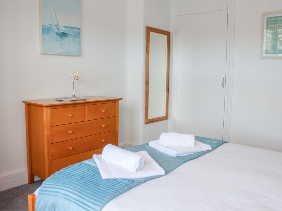 A bedroom with a bed and dresser at Castleview Apartment, 21 South Embankment Dartmouth